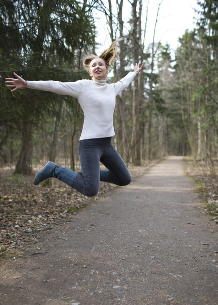 The woman runs on the track in the spring wood - Foto, Bild