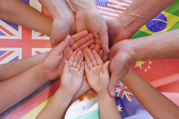 Πολλά χέρια και πολλές σημαίες, παγκόσμιο διεθνές υπόβαθρο - Φωτογραφία, εικόνα