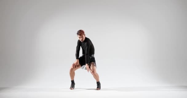 Vyrovnaná a odhodlaná tanečnice kavkazského dědictví zaujímá pódium v vysokých podpatcích na čistém bílém pozadí. Jejich vážné chování dodává jejich výkonům jedinečnou intenzitu.. - Záběry, video