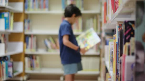 Anya és gyerekek a könyvesboltban. Egy anya segít a gyerekeinek Válasszon egy könyvet - Felvétel, videó