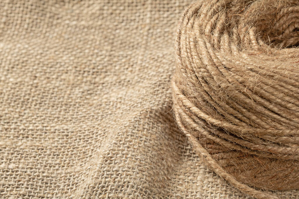 A ball of coarse textured jute threads on a burlap napkin. Close up - Photo, Image