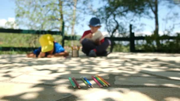 wazig schot van kleine jongens tekenen potloden in het park - Video