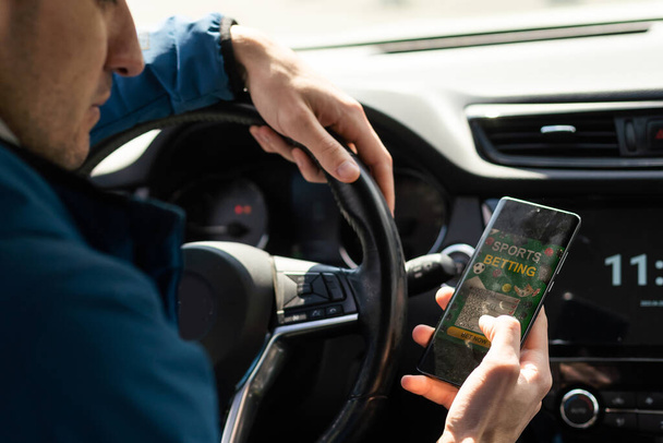 Muž používat mobilní telefon v autě, sázení na sport. - Fotografie, Obrázek