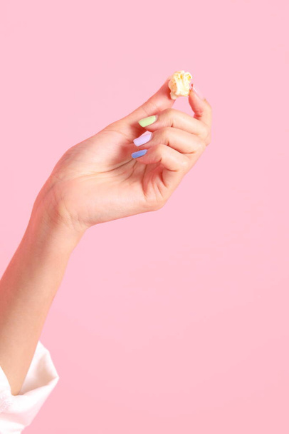 Die Asiatin mit Popcorn in der Hand auf rosa Hintergrund. - Foto, Bild