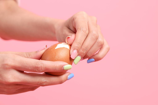 緑の背景に手で卵を食べるアジアの女性. - 写真・画像