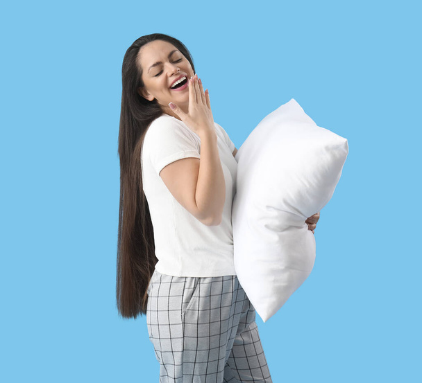 青い背景に柔らかい枕が付いている眠っている若い女性 - 写真・画像