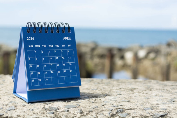 Голубой апрель 2024 календарь на размытом фоне голубого океана. Новогодняя концепция 2024 года - Фото, изображение