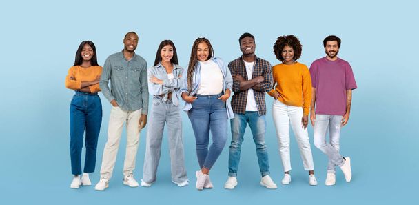 Cheerful confident millennial diverse men and women in casual, enjoy lifestyle, teamwork, isolated on blue studio background, panorama. Work, study, business, ad and offer - Foto, Imagem