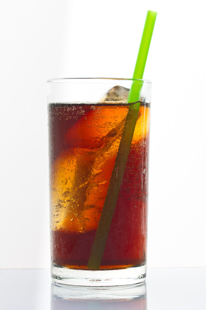 Cola con ghiaccio e paglia in vetro su fondo bianco
 - Foto, immagini