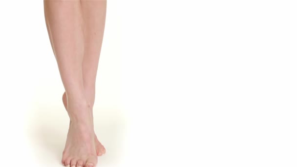 Close up of female legs standing on tiptoe. Beatiful caucasian woman demonstrating her long slim legs. Sexy lady dressed in white panties showing her gorgeous legs isolated on white background - Footage, Video