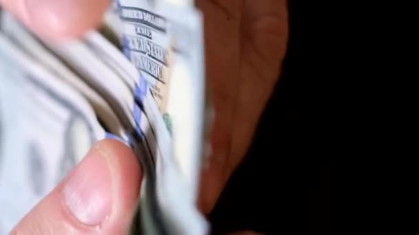 Un hombre cuenta billetes de 100 dólares. Un hombre de negocios cuenta rápidamente su fajo de efectivo. De cerca. Vídeo vertical - Metraje, vídeo