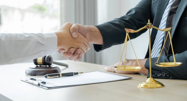 Kézfogás, miután az ügyvéd jogi tanácsadást nyújt üzleti vitás ügyben az irodában az igazságszolgáltatási skálával és kalapáccsal rendelkező férfinak.. - Fotó, kép