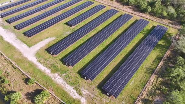 再生可能エネルギーはゼロ・エミッション。クリーンな電気エネルギーを生産するための太陽光発電パネルの多くの行を持つ持続可能な発電所. - 映像、動画