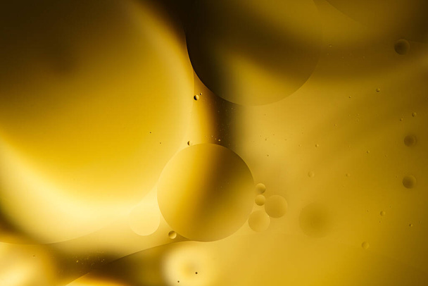 Желтые пузырьки масла на воде, растительное масло. - Фото, изображение