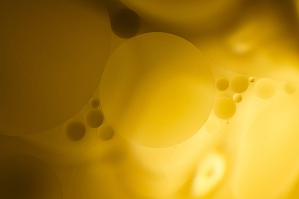 Желтые пузырьки масла на воде, растительное масло. - Фото, изображение