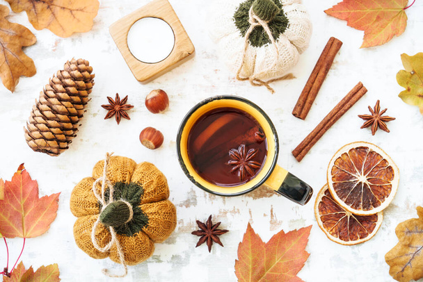 Осінній фон. Затишна осінь на білому. Чашка гострого чаю, осіннє листя, спеції та декор. Плоский простір для копіювання. - Фото, зображення