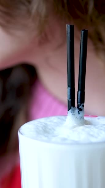 Veselá žena pije ledové latté s kovovou slámou ve venkovní kavárně. Vysoce kvalitní 4K záběry - Záběry, video