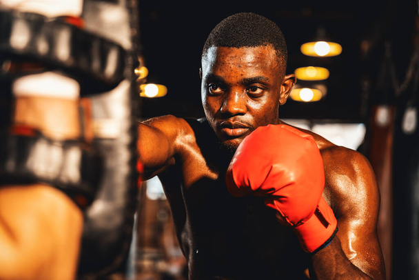 Афроамериканський чорний боксер б'є тренера або тренера, носячи в спортзалі бокс-мішки. Тренування сили і витривалості для професійного боксу. Імпест - Фото, зображення