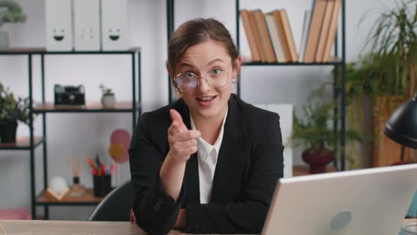 Я выбираю тебя. Кавказская молодая бизнес-женщина программист программного обеспечения работает на офисном ноутбуке, указывая на камеру, с радостным выражением лица, делая выбор, указывая направление. Фрилансерша - Кадры, видео