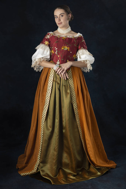Mujer renacentista, Tudor, georgiana o de fantasía alta con un corpiño bordado con una camiseta de lino y una falda larga de dos piezas sobre un fondo de estudio - Foto, Imagen