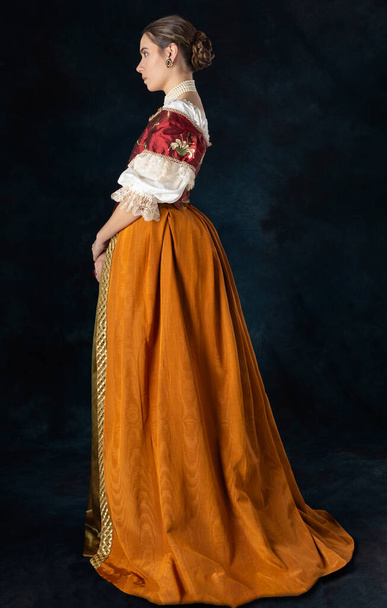 Αναγέννηση, Τυδώρ, Γεωργιανή ή γυναίκα υψηλής φαντασίας που φοράει κεντημένο μπούστο με λινό φανελάκι και μακριά φούστα δύο τεμαχίων σε φόντο στούντιο - Φωτογραφία, εικόνα
