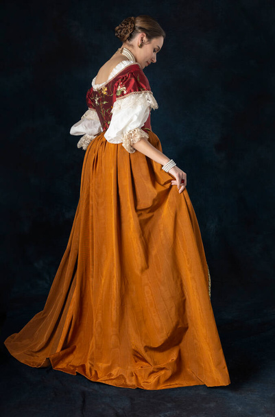 Rönesans, Tudor, Gürcü, ya da süslü fantezi kadın keten bir fanila ve stüdyo arka planına karşı uzun iki parçalı etek giyiyor. - Fotoğraf, Görsel