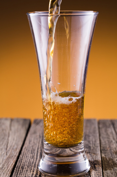Copo de cerveja em um fundo dourado
. - Foto, Imagem