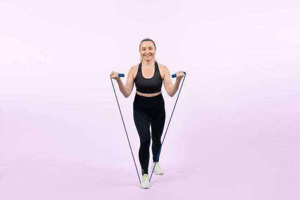 Vücut uzunluğu tam, atletik ve sportif yaşlı kadın izole edilmiş arka planda halat egzersizi yapıyor. Sağlıklı aktif fizik ve vücut bakımı son sınıf öğrencileri. Etki - Fotoğraf, Görsel
