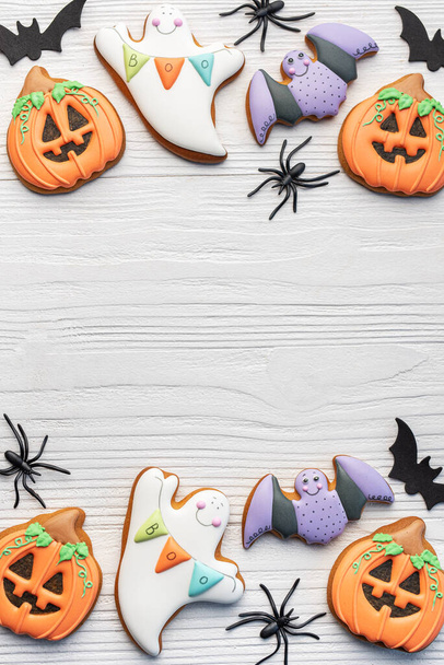 Kolorowe Halloween domowe ciasteczka na białym drewnianym tle. - Zdjęcie, obraz