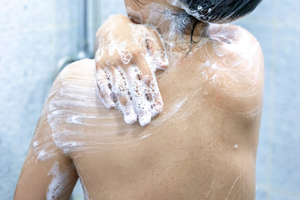 彼女の手でシャワーを浴びている女性 - 写真・画像