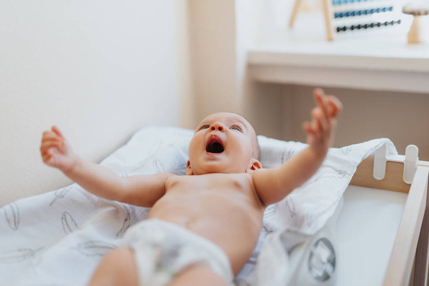 Ένα χαριτωμένο μωρό λαμβάνει πλήρη φροντίδα και εξέταση από έναν ειδικό γιατρό σε ένα δωμάτιο νοσοκομείου. - Φωτογραφία, εικόνα