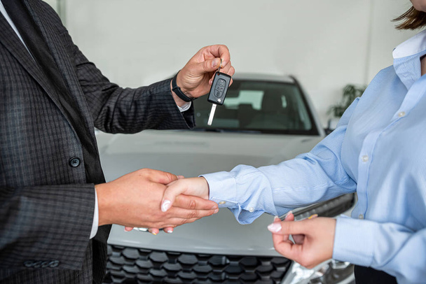 remise des clés de voiture de vendeur des ventes de voiture au propriétaire au showroom, gros plan - Photo, image