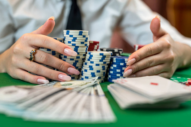 ゲームに勝った後の貪欲なポーカープレーヤーは、テーブルから100ドル札のチップを取ります。ポーカーギャンブル。隔離された - 写真・画像