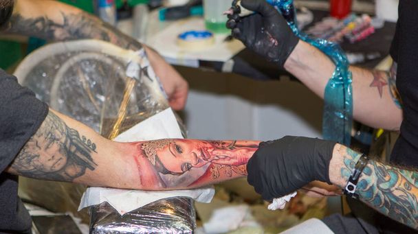 Milano Ιταλία: 2014 01 10 Milano Tattoo Convention, μια δωρεάν εκδήλωση για τατουάζ και κουλτούρα τατουάζ πόδι με γυναικείο πρόσωπο. Υψηλής ποιότητας φωτογραφία - Φωτογραφία, εικόνα