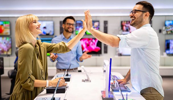 Shopping a new digital device. Happy couple buying a smartphone in store. Technology social media people concept. - Φωτογραφία, εικόνα
