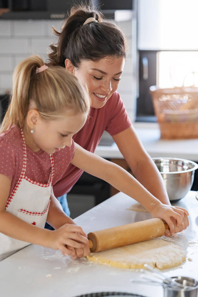 šťastná matka a dcera připravují koláč společně v kuchyni - Fotografie, Obrázek