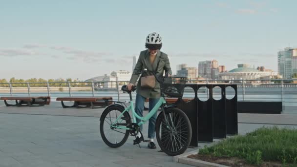 Long shot de travailleuse de bureau portant des vêtements décontractés intelligents parking et verrouillage de son vélo puis aller au travail - Séquence, vidéo