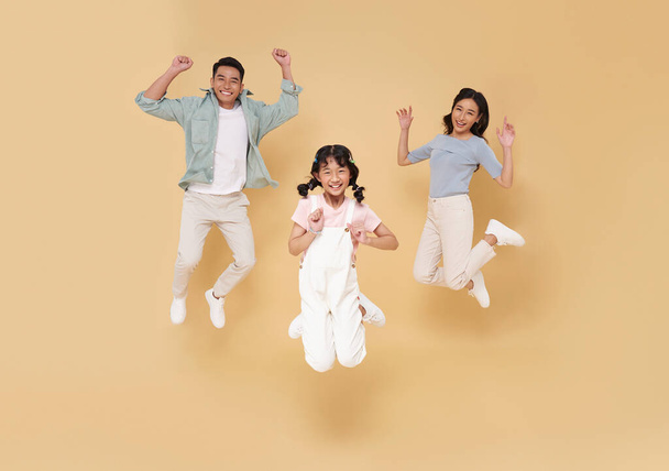 Portrait asian family fun jumping together isolated on nude color studio background.  - Фото, изображение