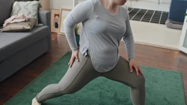 Colpo palmare di giovane donna caucasica con sindrome di Down che fa esercizio di stretching a casa - Filmati, video