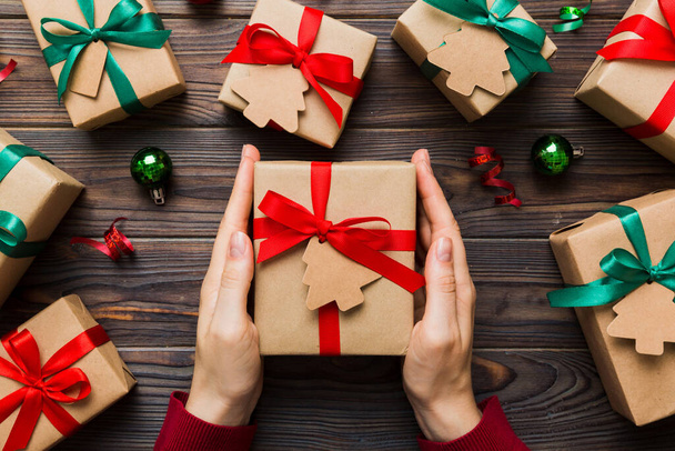 Женщина держит в руках подарочную коробку, готовит сюрприз к празднику, вид сверху, Рождество и Новый год. - Фото, изображение