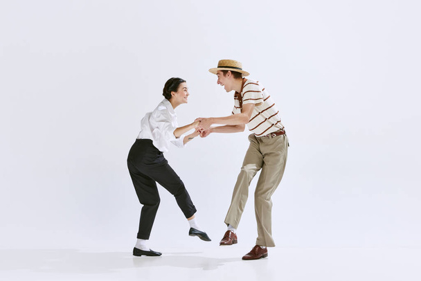 Artistic, talented young people, man and woman in stylish retro clothes dancing isolated on white studio background. Concept of art, hobby, retro dance style, choreography, beauty. Ad - Foto, afbeelding