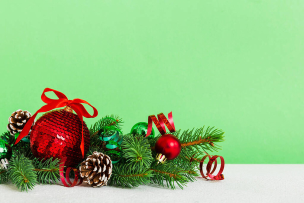 Πρωτοχρονιά χριστουγεννιάτικο δέντρο παιχνίδι, κλαδιά ενός χριστουγεννιάτικου δέντρου, διακοσμήσεις Πρωτοχρονιάς σε έγχρωμο φόντο. - Φωτογραφία, εικόνα