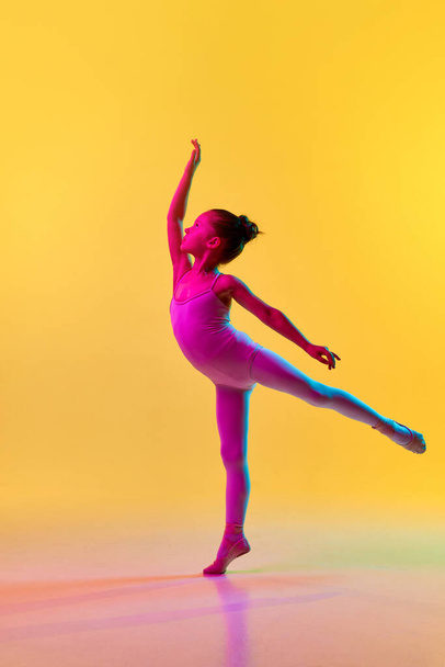 Retrato de pequena bailarina adorável pré-escolar menina dançarina em leotard e em pontas legging branco em pé posando em luz de néon sobre o fundo do estúdio. Conceito de beleza, moda, hobby, dança - Foto, Imagem