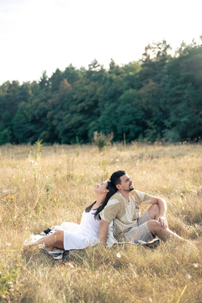 Happy married man and woman on a date relaxing in a field in summer, quality time together, close relationship, romance in marriage. - Photo, Image