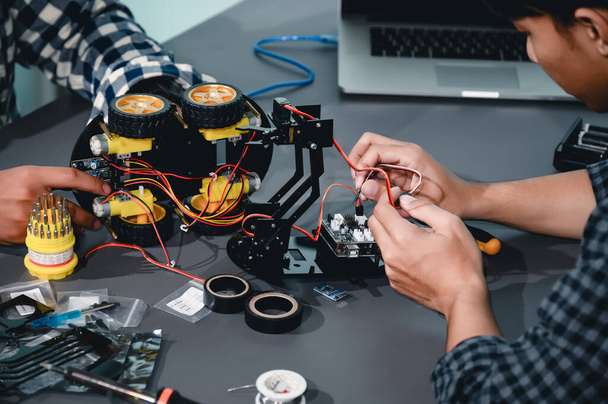 Ingénieur asiatique étudiants assemblant des kits de robotique. Apprenant le contrôle mécanique, la robotique combine l'informatique, l'électricité, la mécanique et la détection. Habiliter les ingénieurs et le concept de développement. - Photo, image