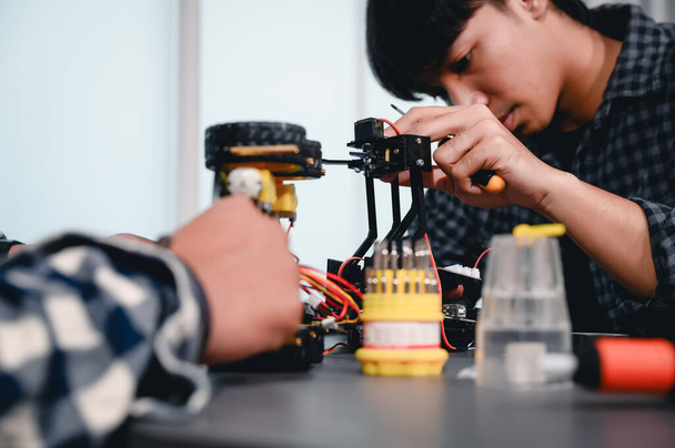 Engineer Asian Students Assembling Robotics Kits. Learning Mechanical Control, Robotics combines computer, electrical, mechanical, and sensing. Empowering Engineers and Development Concept. - Photo, image