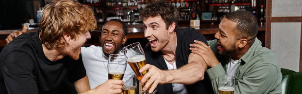 banner de amigos multiculturais animado clinking com copos de cerveja no bar, homens em despedida de solteiro - Foto, Imagem