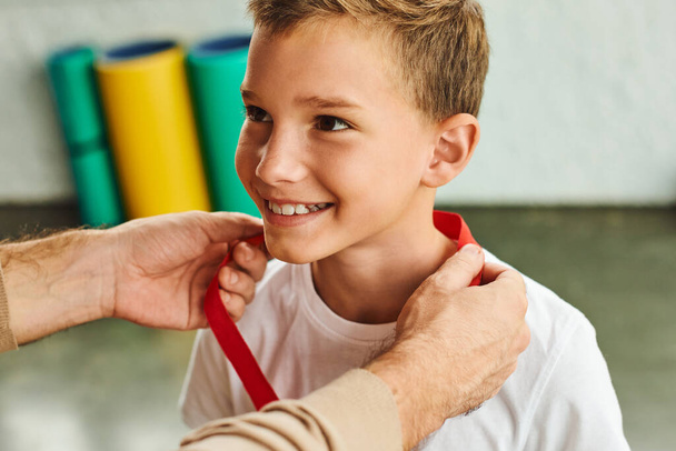 hombre recortado otorgando alegre niño preadolescente con medalla de oro, ganador del deporte infantil - Foto, Imagen