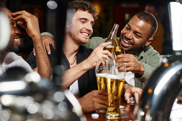 kolme rotujenvälinen ystäviä paahtoleipää lasit olutta viettäessään aikaa baarissa, mies ystävyys - Valokuva, kuva