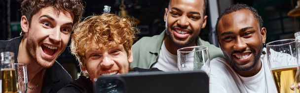 Barda bekarlığa veda partisi sırasında akıllı telefondan selfie çeken ve bira içen ırklar arası erkekler pankartı. - Fotoğraf, Görsel
